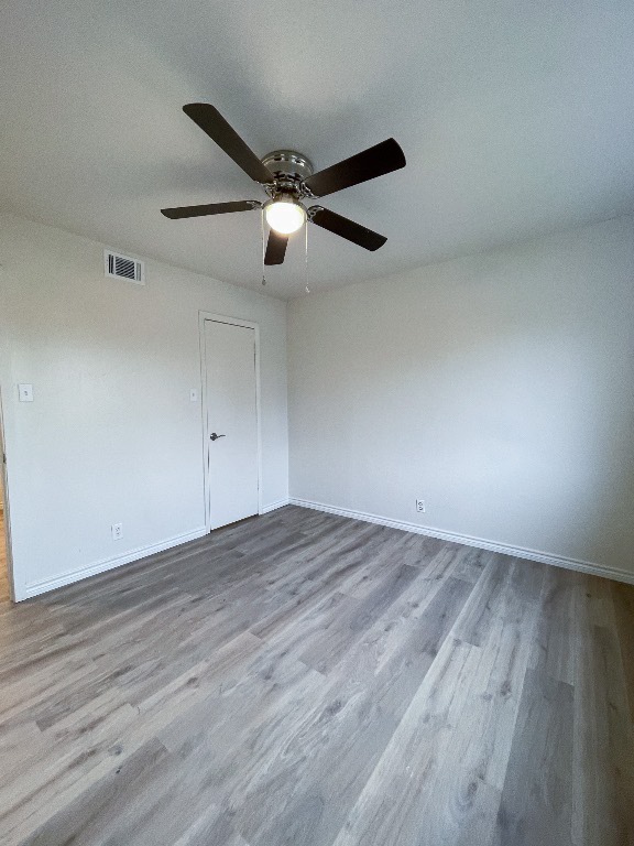 2401 Bucks Run, Unit A Austin, TX 78744 - Photo 31 of 33 an empty room with wooden floor and windows