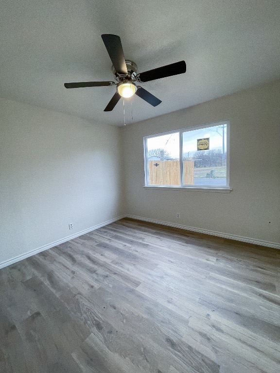 2401 Bucks Run, Unit A Austin, TX 78744 - Photo 32 of 33 an empty room with wooden floor ceiling fan and windows