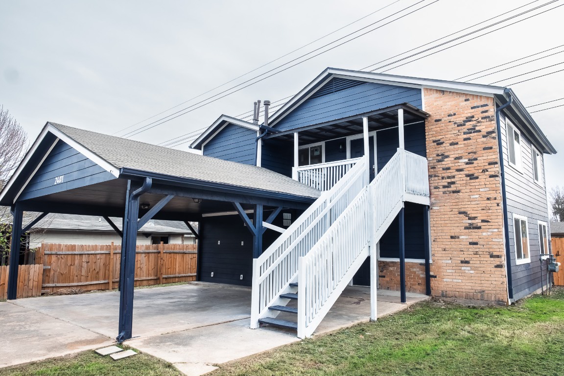 2401 Bucks Run, Unit A Austin, TX 78744 - Photo 10 of 33 Rear view of property featuring a patio area, brick siding, and stairway