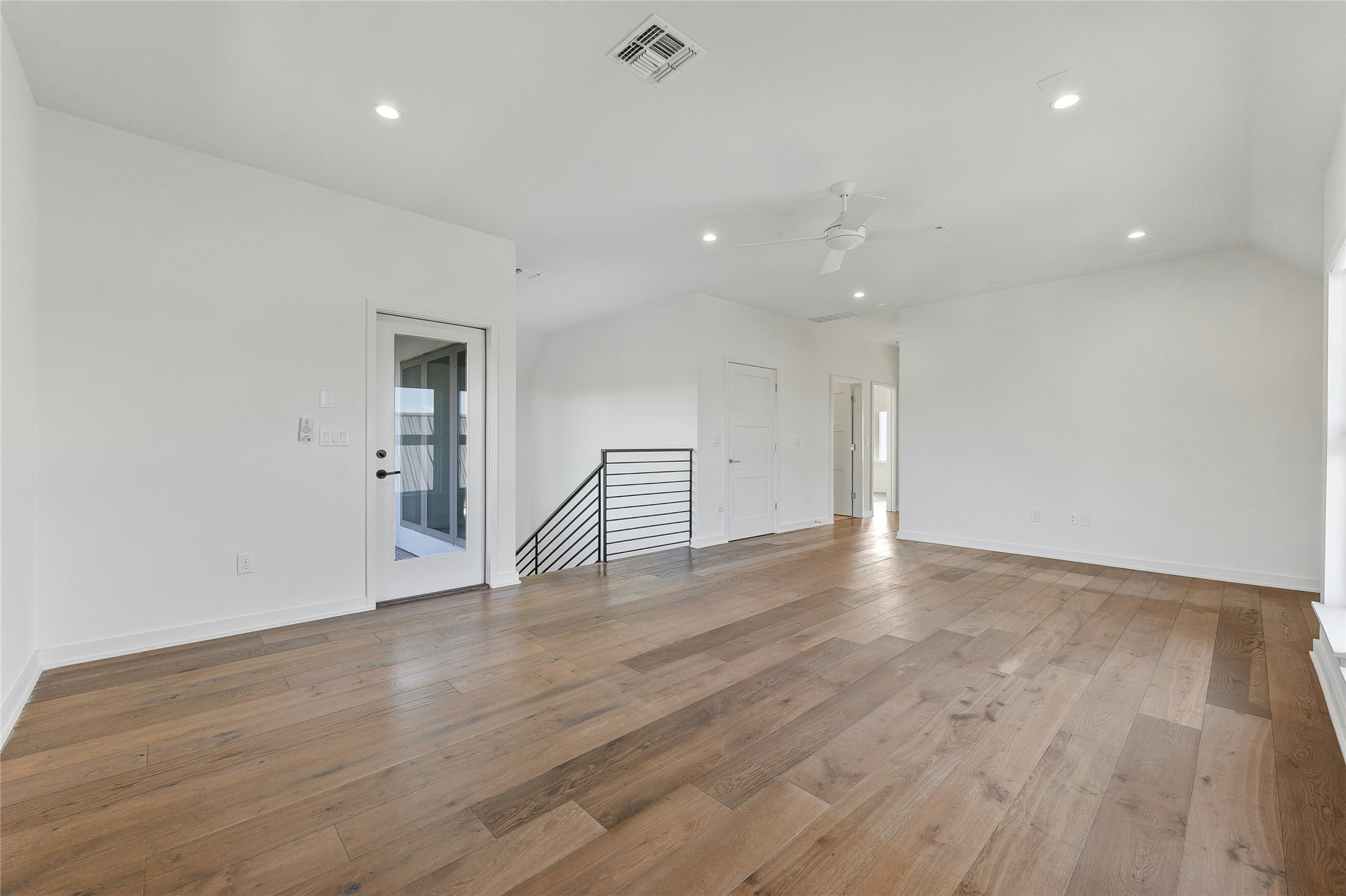 2518 Sutherland Street Austin, TX 78746 - Photo 20 of 30 Hardwood flooring extends throughout this expansive living space, offering a clean, contemporary design.