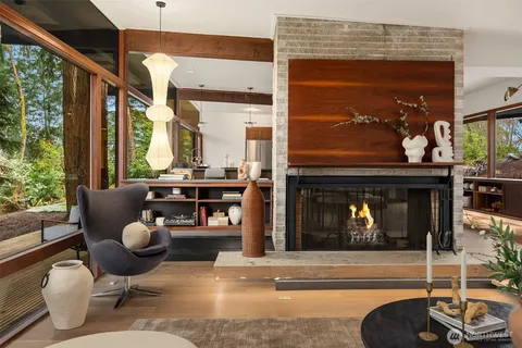 a living room with furniture a fireplace and a floor to ceiling window