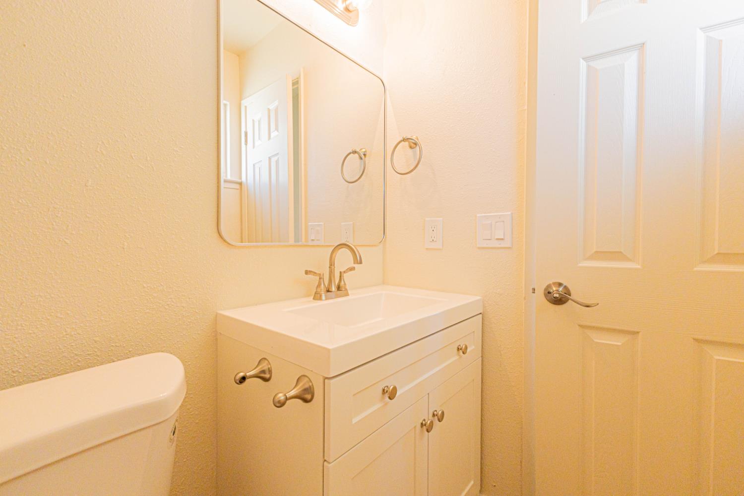17925 Rodeo Drive Madera, CA 93638 - Photo 20 of 26 a bathroom with a sink a toilet and a mirror