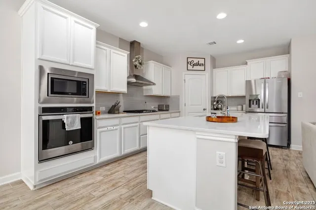 a kitchen with stainless steel appliances a stove microwave and a refrigerator
