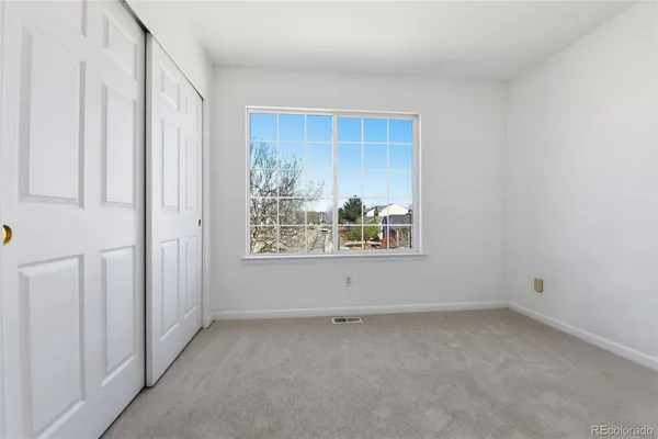 an empty room with a ceiling fan and window