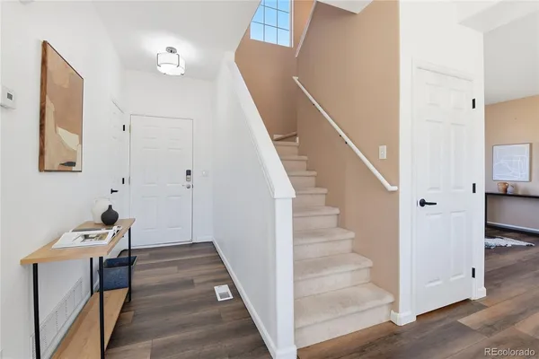 a view of a hallway with wooden floor and staircase