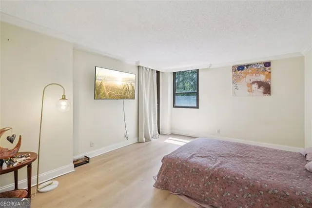 a bedroom with bed and paintings on the wall