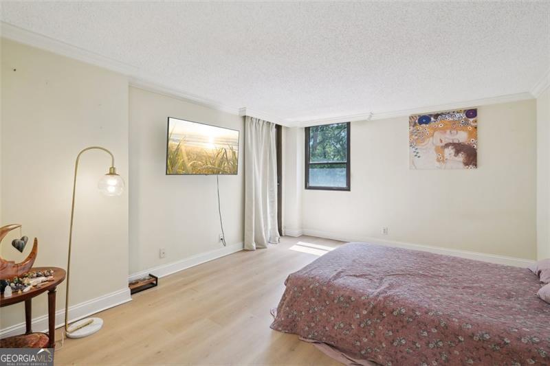 3530 Piedmont Road Northeast, Unit 2I Atlanta, GA 30305 - Photo 12 of 26 a bedroom with bed and paintings on the wall