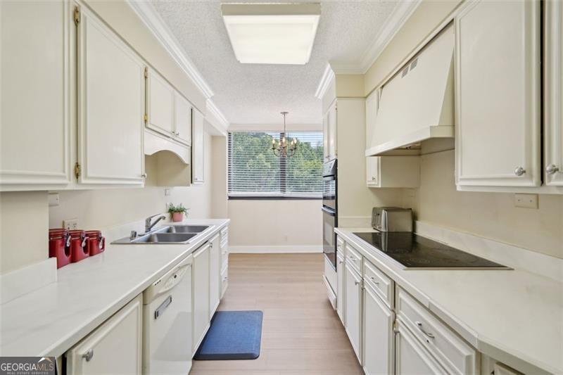 3530 Piedmont Road Northeast, Unit 2I Atlanta, GA 30305 - Photo 9 of 26 a kitchen with granite countertop a sink a window stainless steel appliances and cabinets
