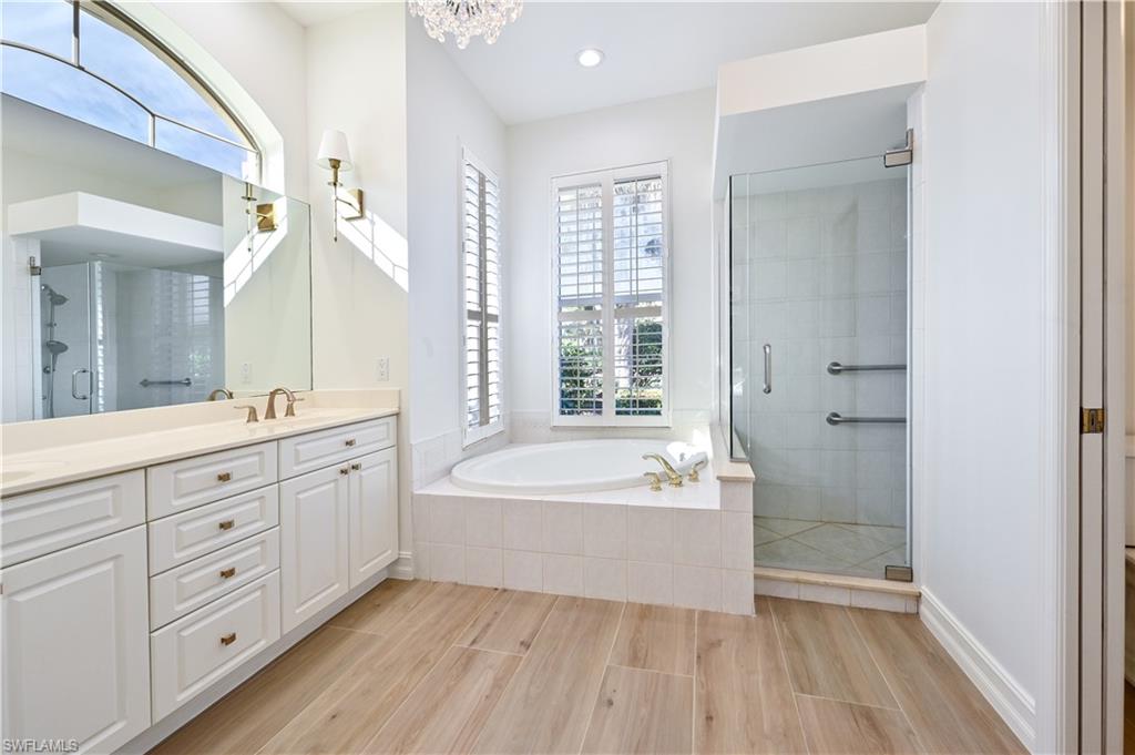2312 Harrier Run Naples, FL 34105 - Photo 16 of 21 a spacious bathroom with double vanity a large mirror and a bathtub