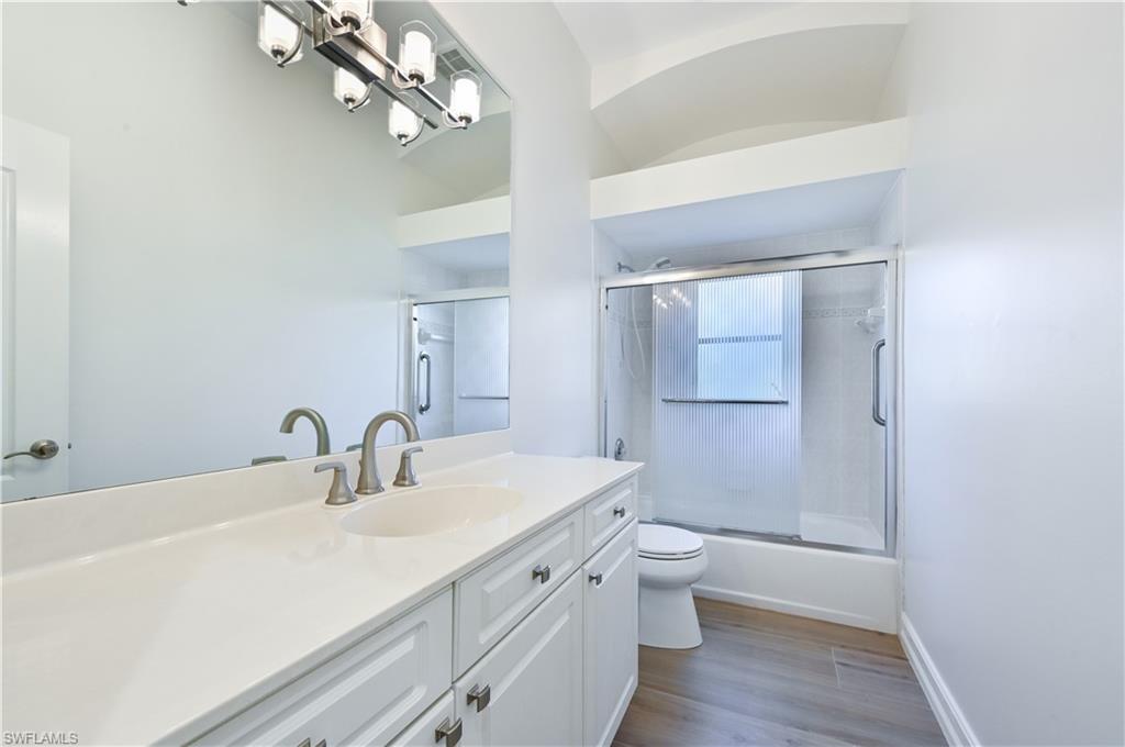 2312 Harrier Run Naples, FL 34105 - Photo 18 of 21 a bathroom with a sink a toilet and a large mirror