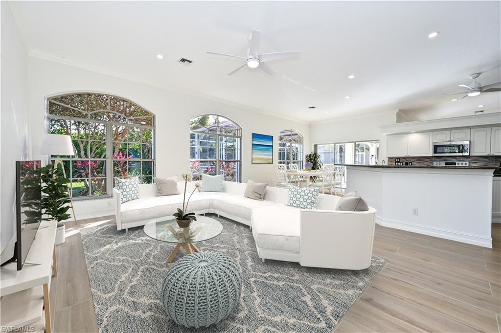 2312 Harrier Run Naples, FL 34105 - Photo 10 of 21 a living room with fireplace furniture and a large window