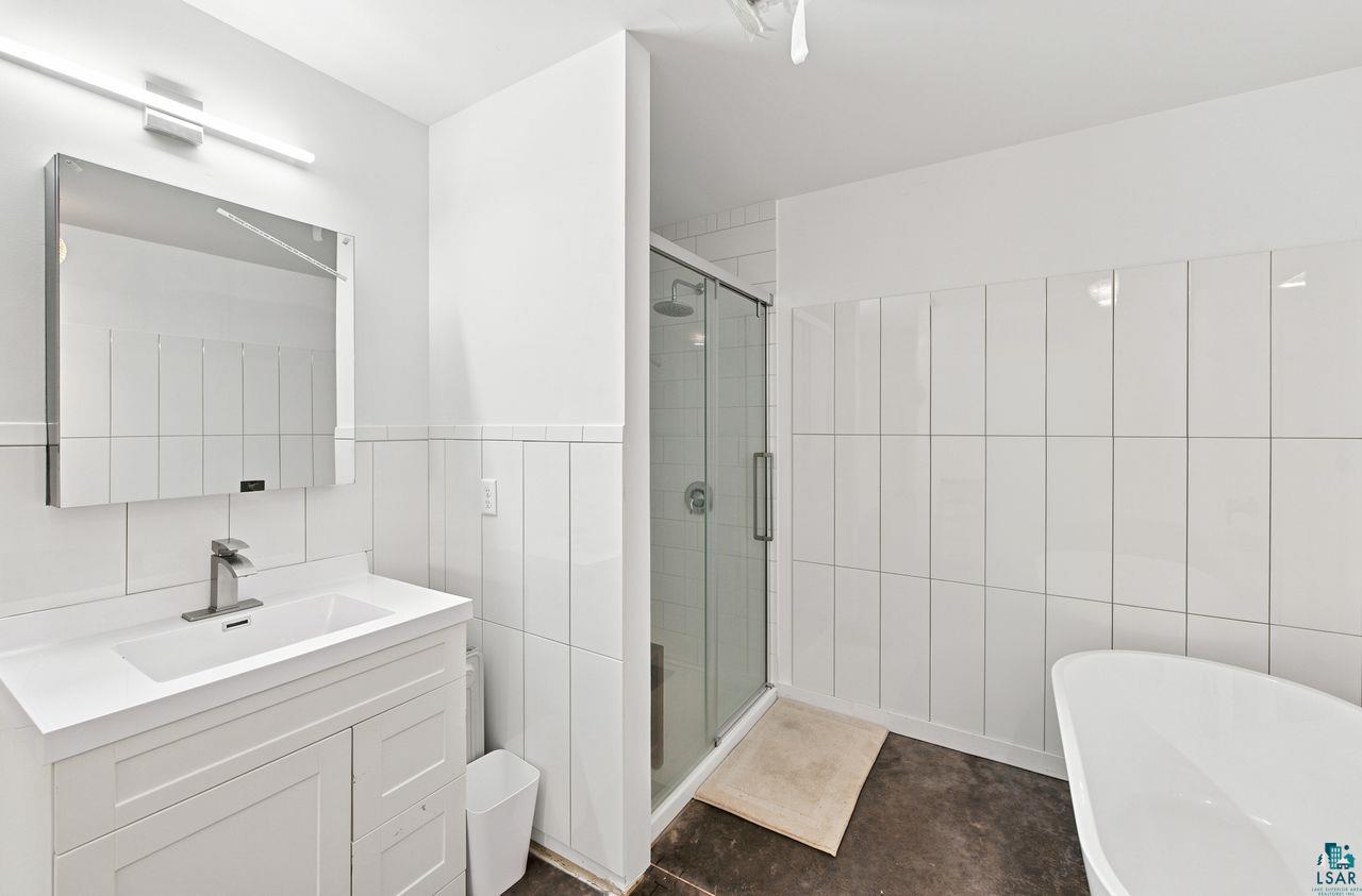 5400 Eightmile Lake Road Iron River, WI 54847 - Photo 16 of 37 Bathroom featuring a white vanity with integrated sink, chrome faucet, and rectangular mirror with integrated lighting