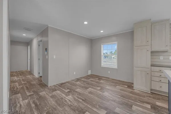 a large kitchen with stainless steel appliances granite countertop a stove top oven a sink dishwasher and a refrigerator with wooden floor