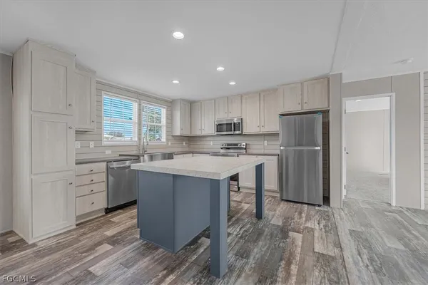 a kitchen with refrigerator cabinets and large window