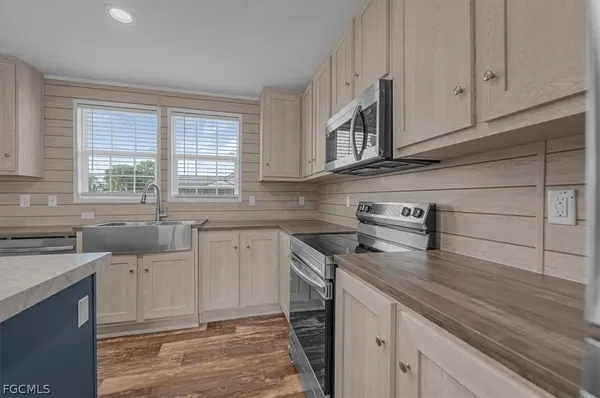a kitchen with a stove a refrigerator a sink and dishwasher with wooden floor