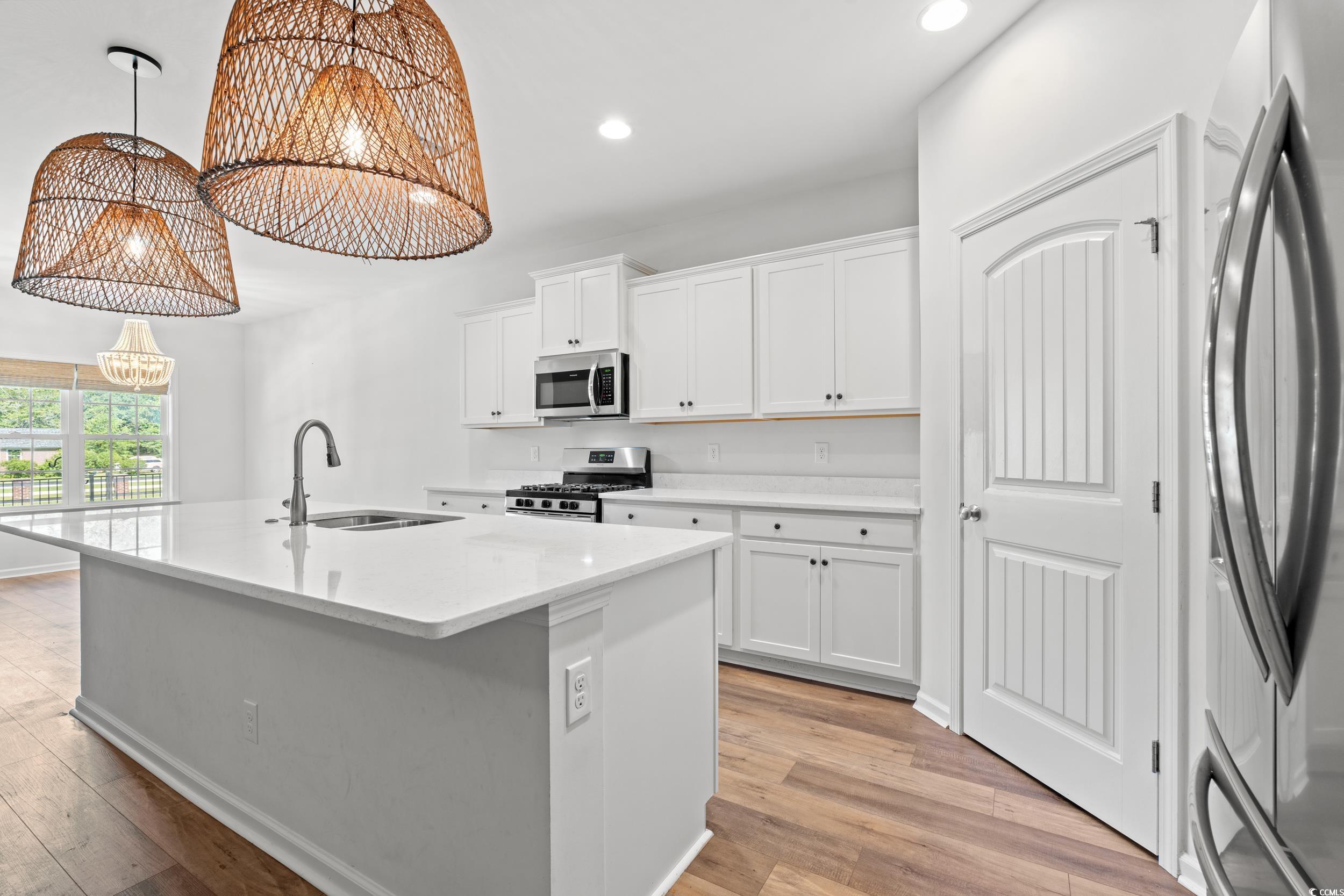 3026 Millstone Place Georgetown, SC 29440 - Photo 12 of 34 Kitchen featuring a chandelier, stainless steel appliances, a kitchen island with sink, light wood-style floors, and recessed lighting