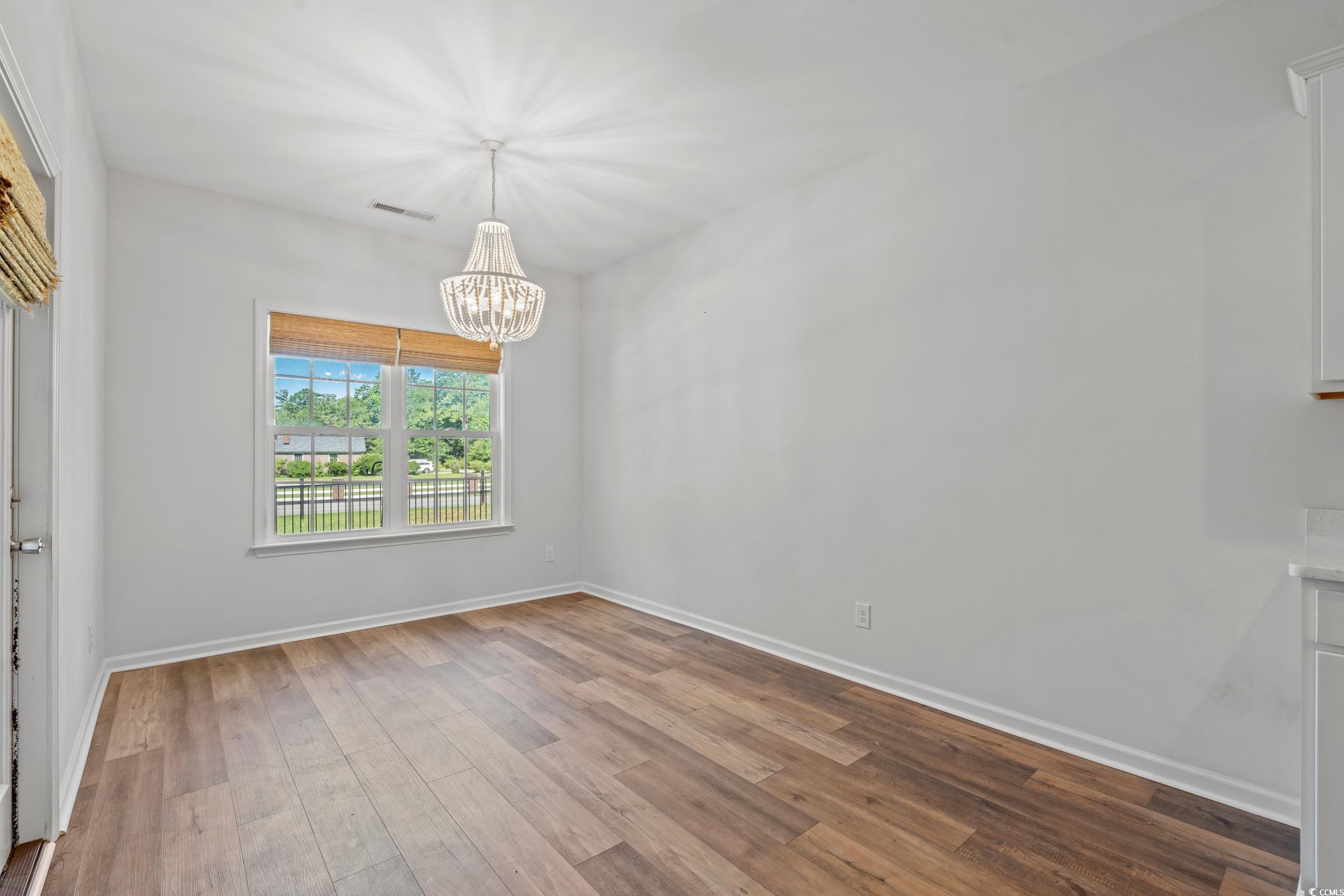 3026 Millstone Place Georgetown, SC 29440 - Photo 15 of 34 Unfurnished room featuring a chandelier and LVP flooring, door to the screened in back porch