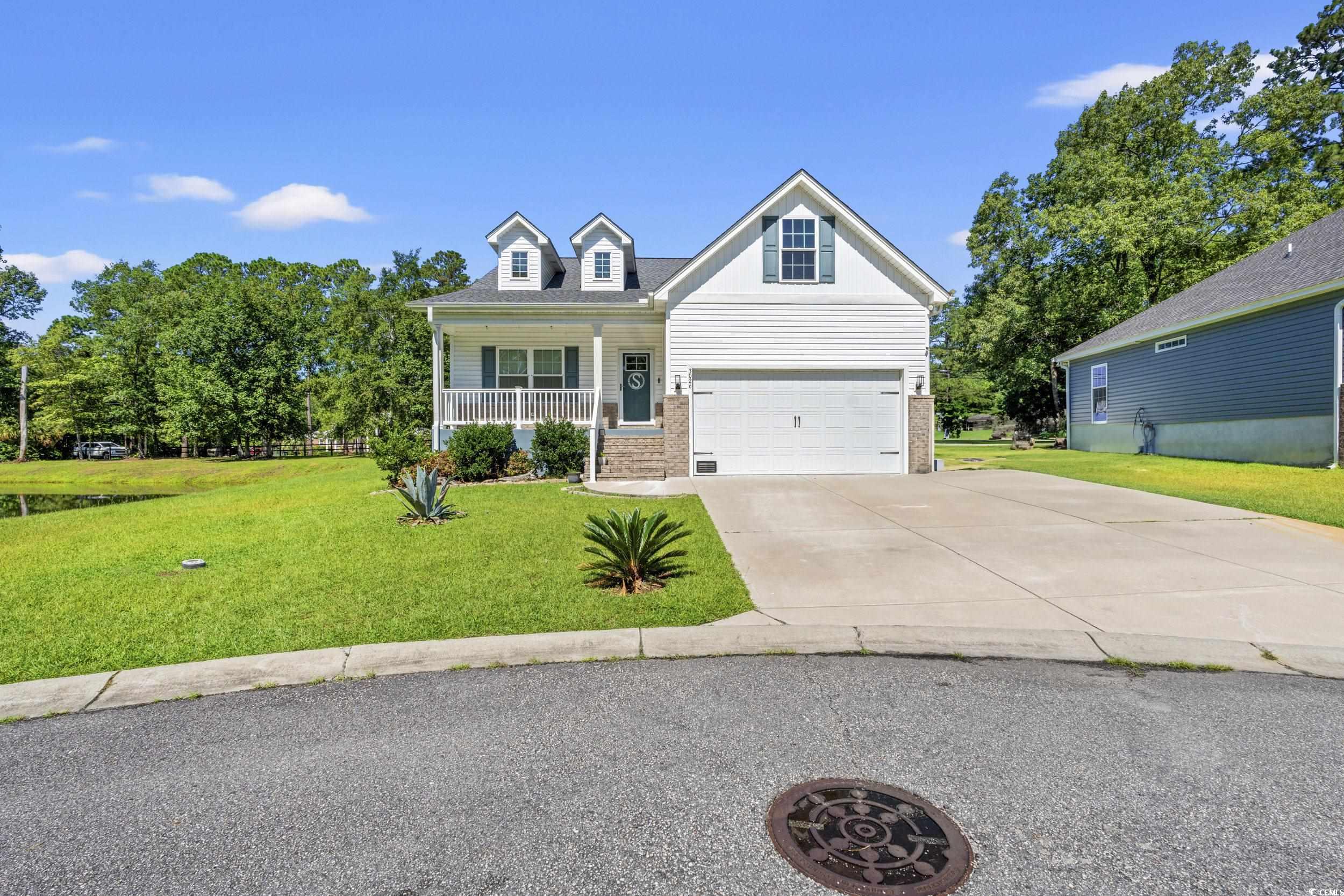 3026 Millstone Place Georgetown, SC 29440 - Photo 25 of 34 View of front of property featuring a porch, concrete driveway, a front yard