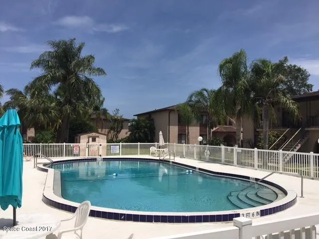 a view of a grey house with a small yard
