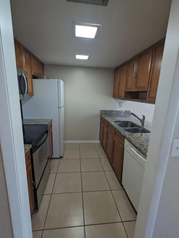 a kitchen with a sink a stove top oven and cabinets