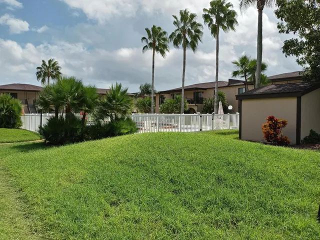 a backyard of a house with trees and outdoor seating