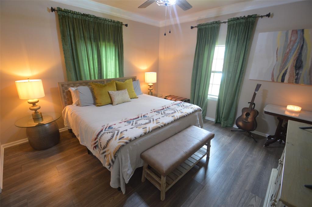 261 Red Road Howe, TX 75459 - Photo 20 of 40 a bedroom with a bed and a mirror with wooden floor