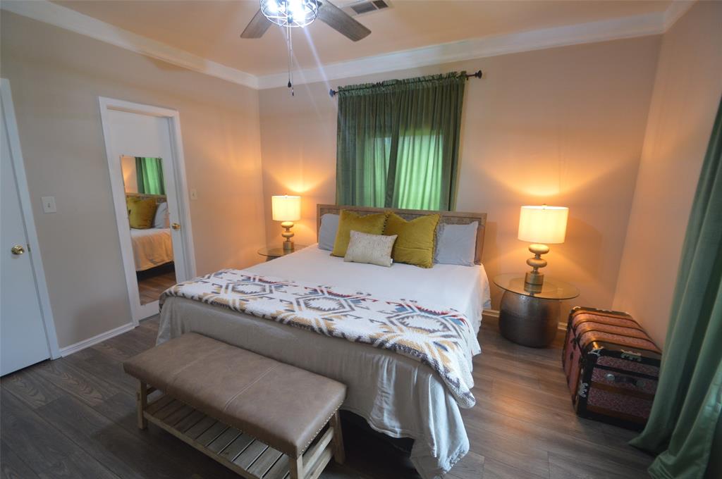 261 Red Road Howe, TX 75459 - Photo 22 of 40 a bedroom with a bed and a chandelier