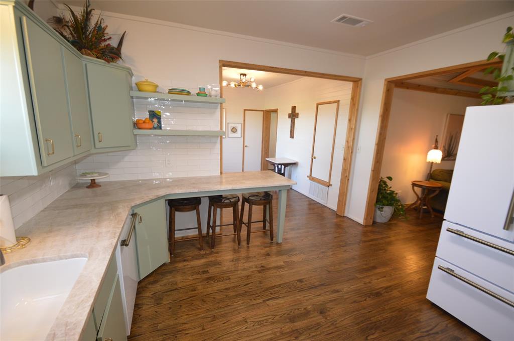 261 Red Road Howe, TX 75459 - Photo 10 of 40 a kitchen with kitchen island a counter top space a sink a refrigerator and a view of living room