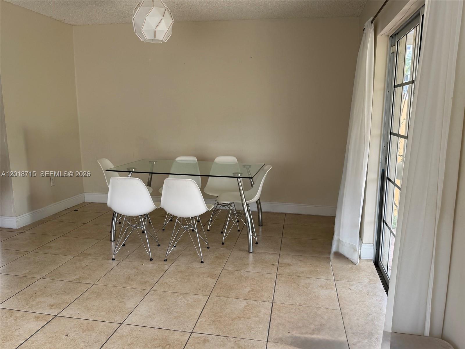 6720 Southwest 21st Street, Unit 1 Miami, FL 33155 - Photo 7 of 26 a view of a dining room with furniture and a chandelier