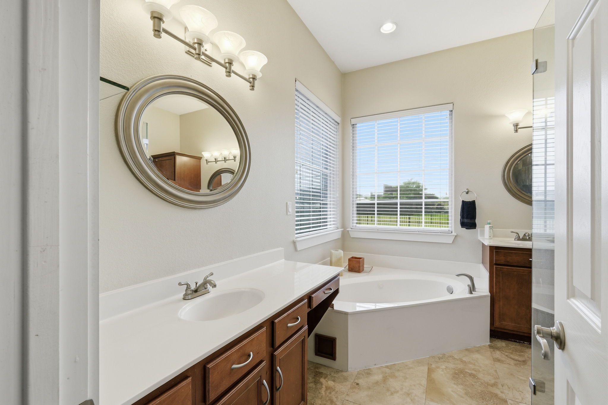 21007 Hodde Lane Pflugerville, TX 78660 - Photo 12 of 30 a bathroom with a bathtub a mirror a sink and a shower