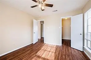 a view of a room with wooden floor and ceiling fan