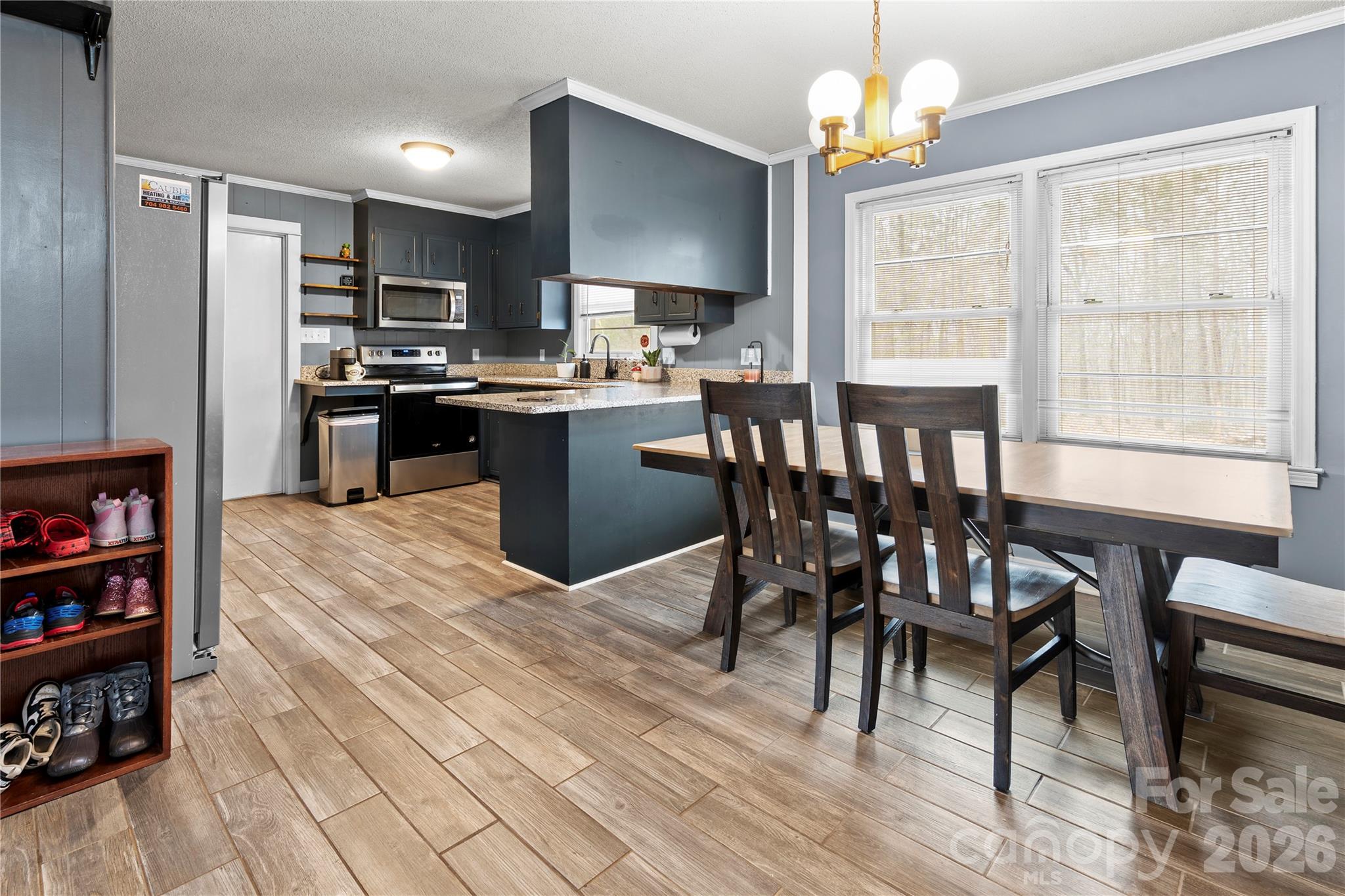 2231 Snuggs Park Road Albemarle, NC 28001 - Photo 8 of 30 a kitchen with stainless steel appliances granite countertop a stove a refrigerator dining table and chairs