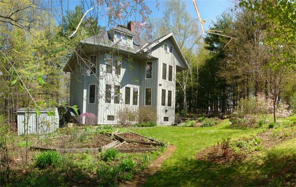 a view of a white house with a big yard and large trees