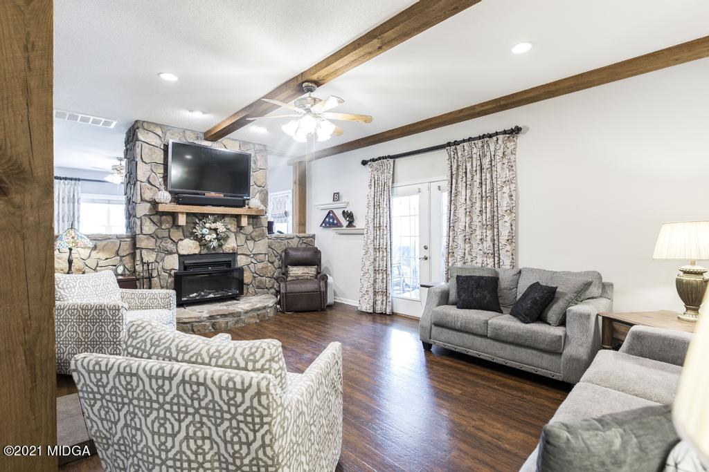 6246 Rogers Road Lizella, GA 31052 - Photo 13 of 48 a living room with furniture a fireplace and a flat screen tv