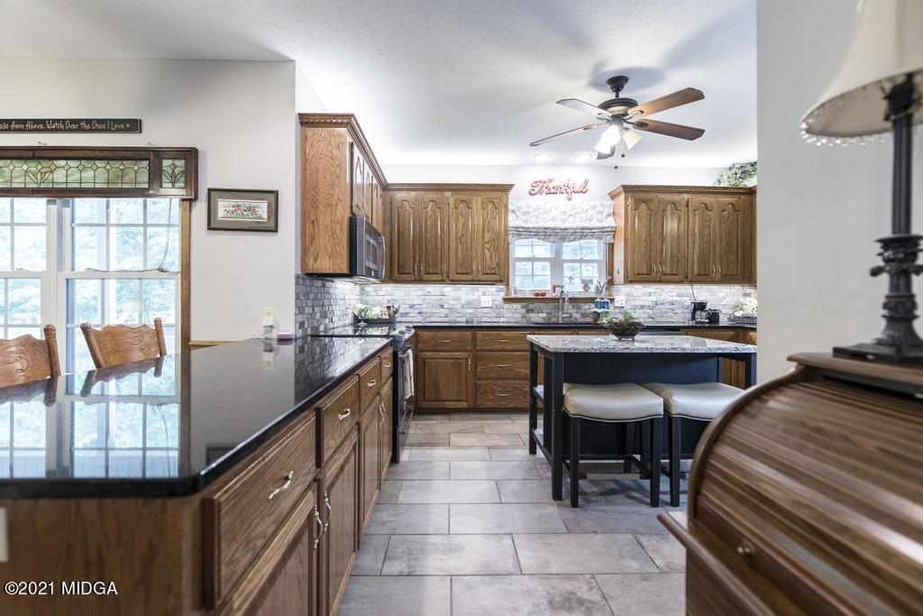 6246 Rogers Road Lizella, GA 31052 - Photo 19 of 48 a kitchen with granite countertop lots of counter top space and dining table