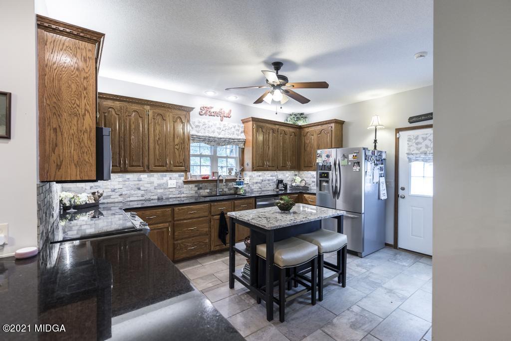 6246 Rogers Road Lizella, GA 31052 - Photo 20 of 48 a kitchen with stainless steel appliances granite countertop a sink stove and refrigerator