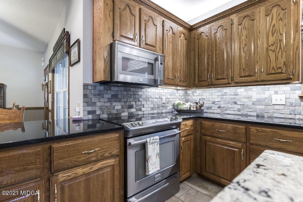 6246 Rogers Road Lizella, GA 31052 - Photo 21 of 48 a kitchen with stainless steel appliances granite countertop a sink a stove and cabinets