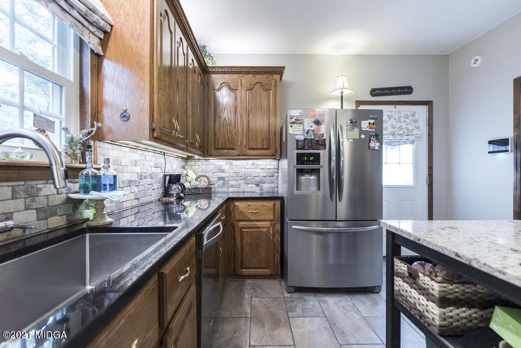 6246 Rogers Road Lizella, GA 31052 - Photo 22 of 48 a kitchen with granite countertop a refrigerator and a sink