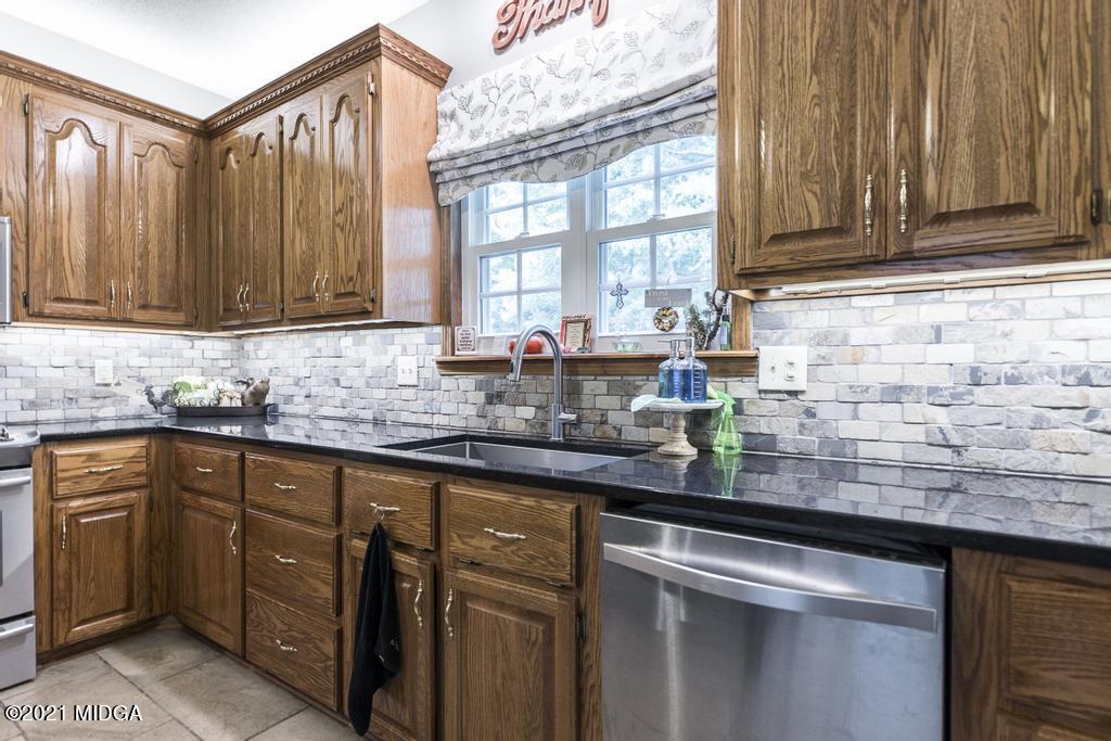 6246 Rogers Road Lizella, GA 31052 - Photo 23 of 48 a kitchen with stainless steel appliances granite countertop a sink a stove and cabinets