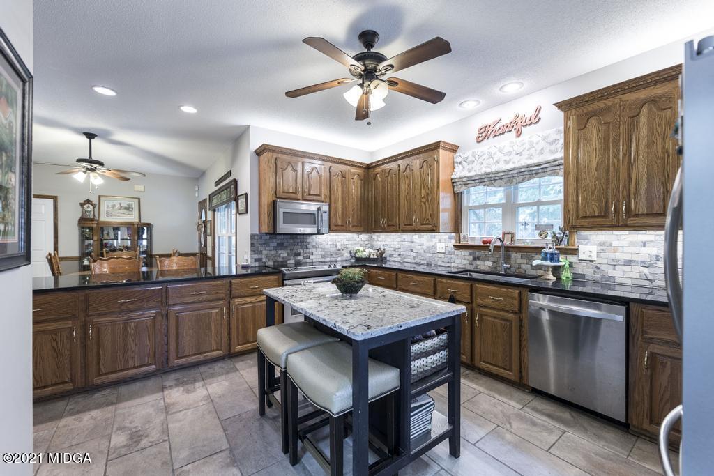 6246 Rogers Road Lizella, GA 31052 - Photo 24 of 48 a kitchen with granite countertop a sink counter top space and stainless steel appliances