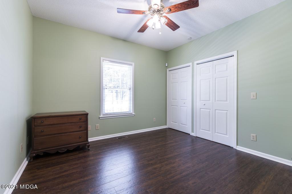 6246 Rogers Road Lizella, GA 31052 - Photo 28 of 48 an empty room with wooden floor fan and windows