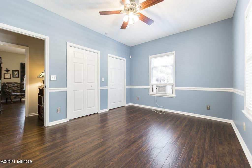 6246 Rogers Road Lizella, GA 31052 - Photo 31 of 48 an empty room with wooden floor chandelier and windows