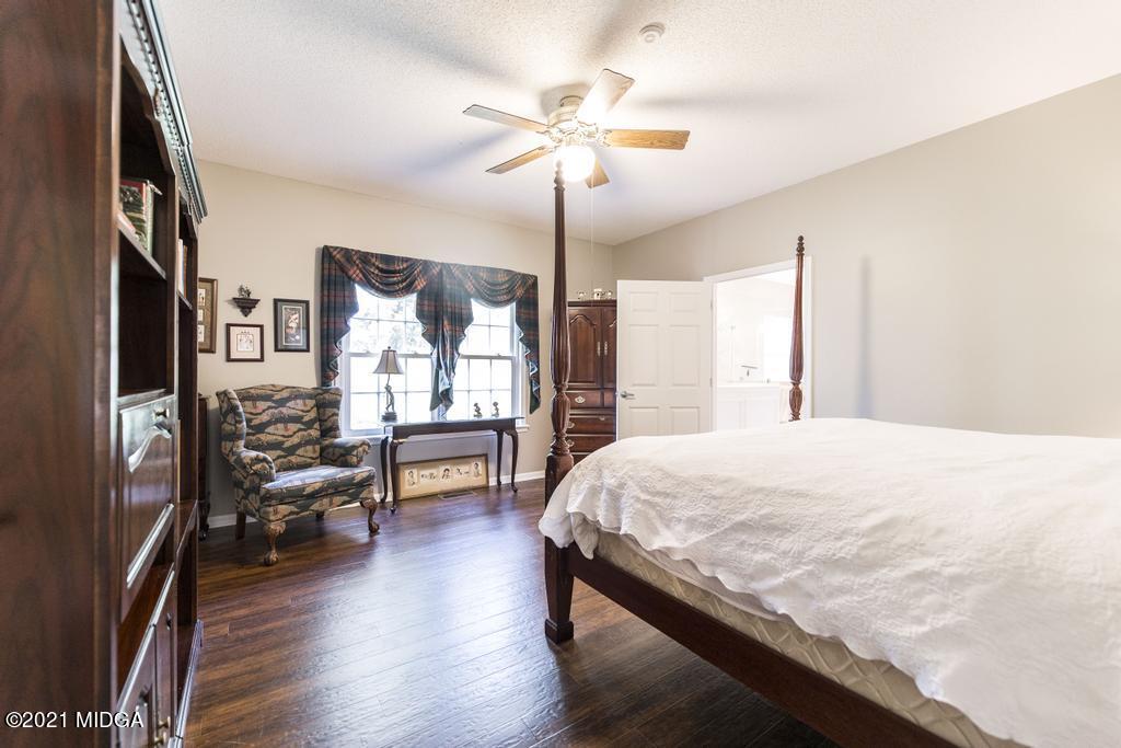 6246 Rogers Road Lizella, GA 31052 - Photo 32 of 48 a bedroom with a bed and a chandelier