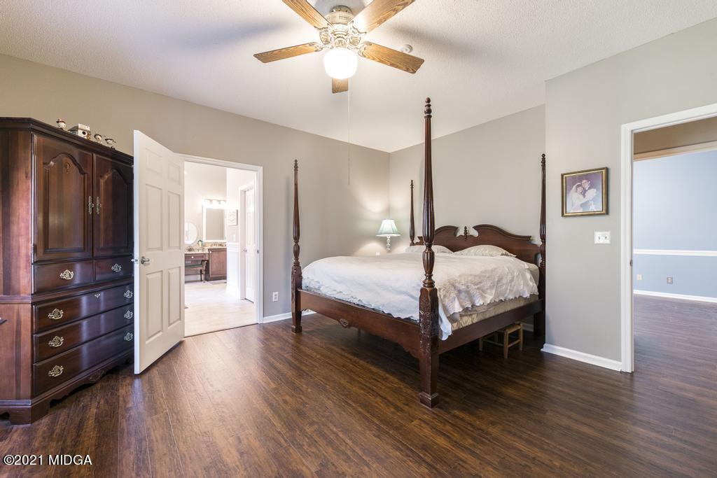 6246 Rogers Road Lizella, GA 31052 - Photo 33 of 48 a bedroom with a bed and a flat tv screen on dresser