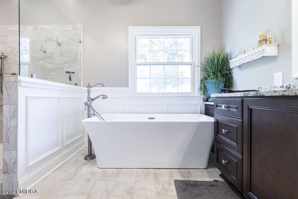 6246 Rogers Road Lizella, GA 31052 - Photo 38 of 48 a white bath tub sitting in a bathroom next to a window