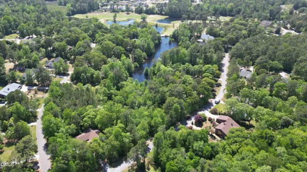 an aerial view of a house with a yard and lake view
