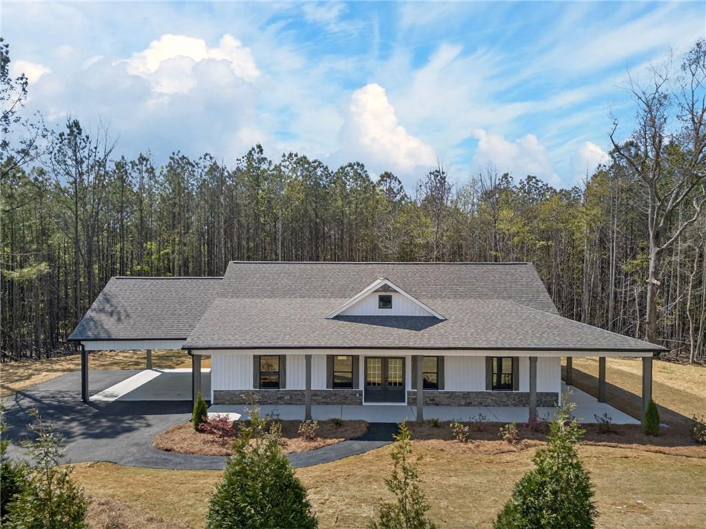 an aerial view of a house with swimming pool and trees in the background