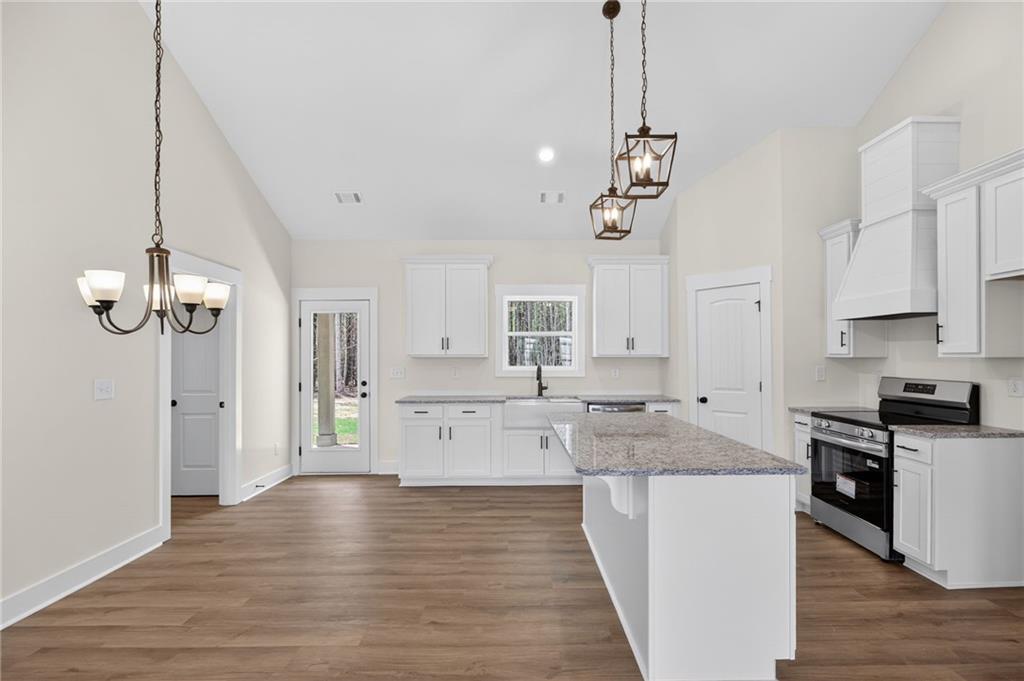 3512 Vinson Mountain Road Rockmart, GA 30153 - Photo 19 of 49 a kitchen with white cabinets stainless steel appliances and wooden floor