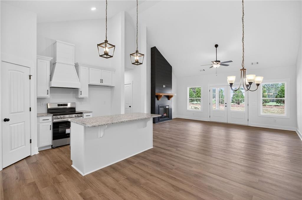 3512 Vinson Mountain Road Rockmart, GA 30153 - Photo 23 of 49 a kitchen with stainless steel appliances kitchen island wooden floors cabinets and a chandelier
