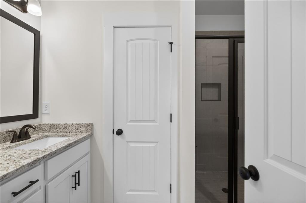 3512 Vinson Mountain Road Rockmart, GA 30153 - Photo 29 of 49 a bathroom with a granite countertop sink and a mirror